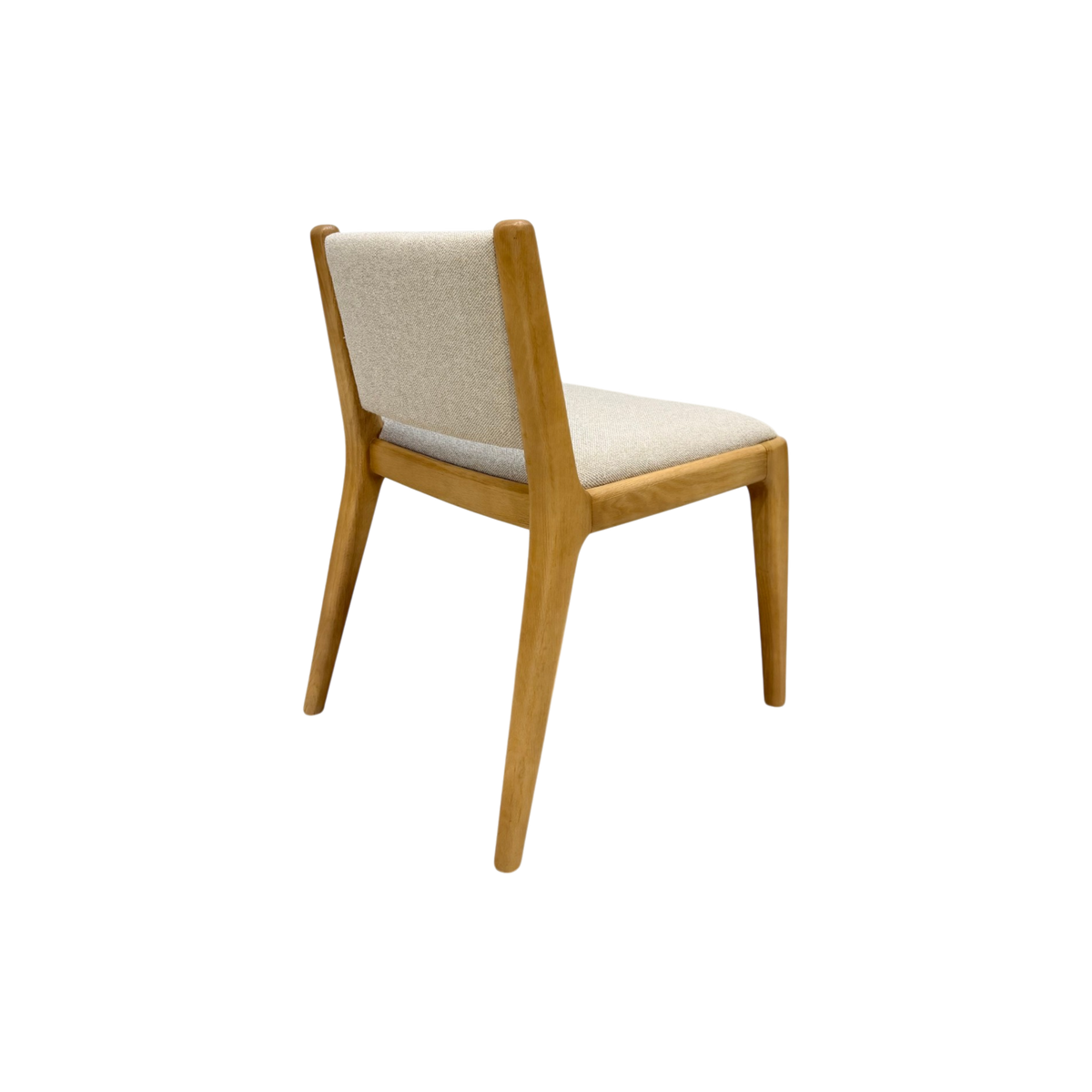 A modern wooden dining chair with a light beige upholstered seat and backrest, shown from a three-quarters angle on a solid white background.