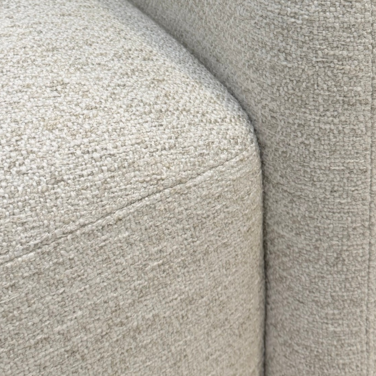 Detail view of Sigma Lounge Chair showing the rounded seat edge, curved arm and textured Grey Oak upholstery.