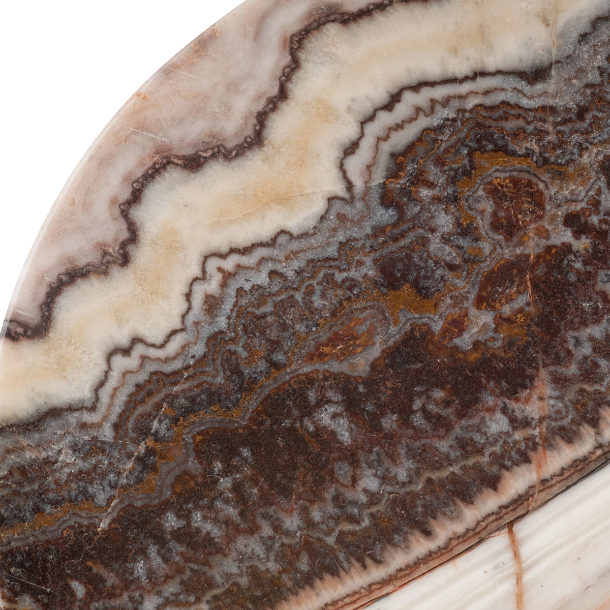 Close-up showing the dark brown onyx section of the Onyx Side Table top, with feathered pink edges, amber patches, and a fine vein crossing into the cream layer.