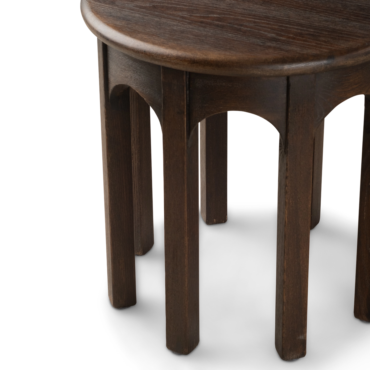Calloway Side Table angled close view in dark brown elm, highlighting the arched aprons, ring of square legs, and rounded tabletop edge.