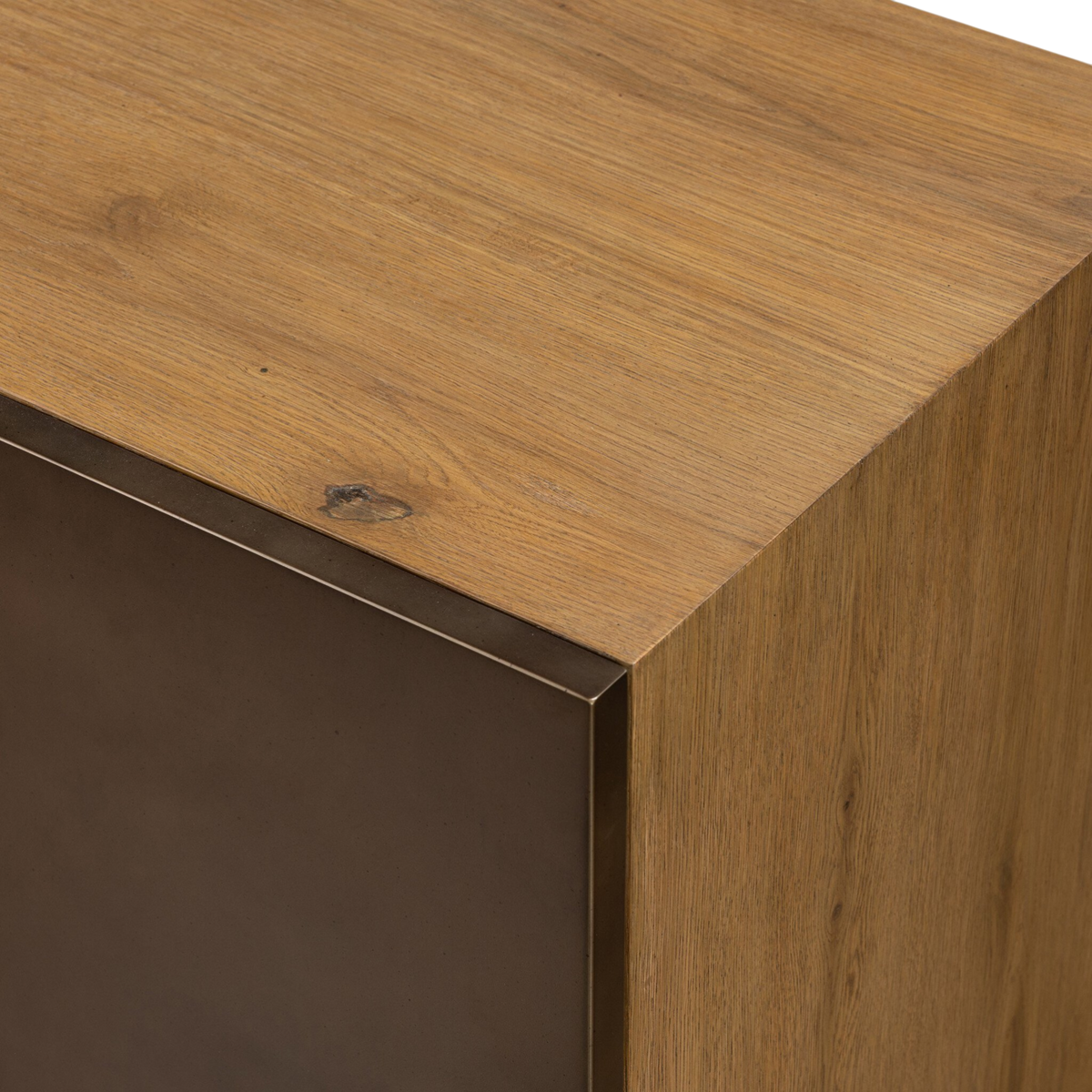 Detail view of the Sonoma Sideboard highlighting the warm smoked oak grain and dark metal cladding along the cabinet edge.