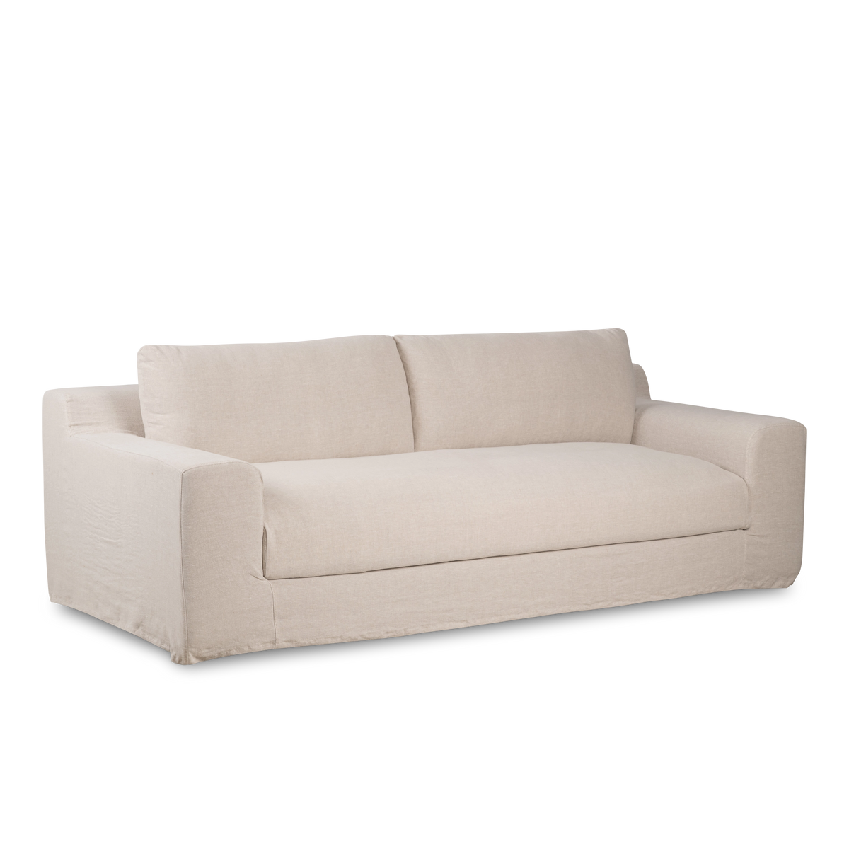 Babylon Sofa in an angled front view in natural linen, with a slipcovered base, single seat cushion and loose back cushions.