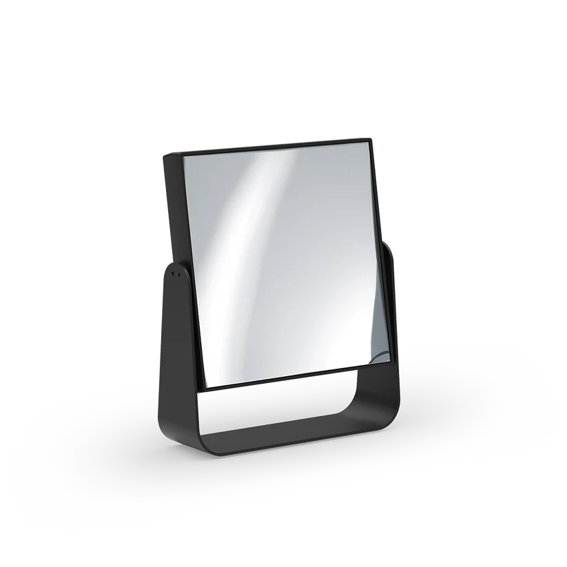 Cosmetic Mirror shown at an angle in black matte metal, highlighting the square mirror, slim frame, and curved base.