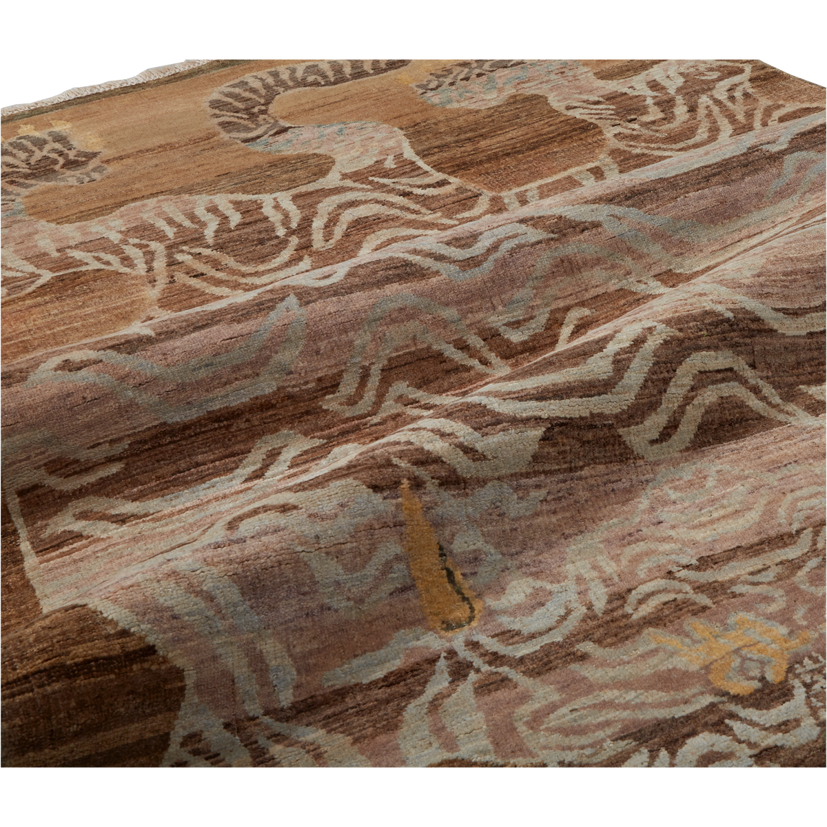 A close-up of a textured area rug featuring a detailed, hand-knotted pattern of stylized deer and abstract organic shapes in earthy brown, beige, and muted gray tones.