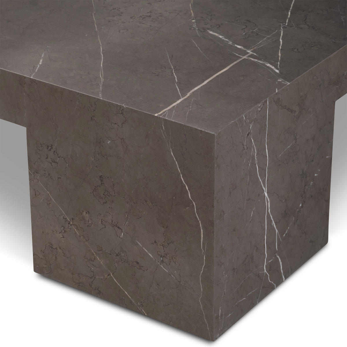 Duvall Coffee Table close-up of a corner leg in warm gray Petra Grey marble, showing the square block base beneath the slab top and fine white veins running down its faces.