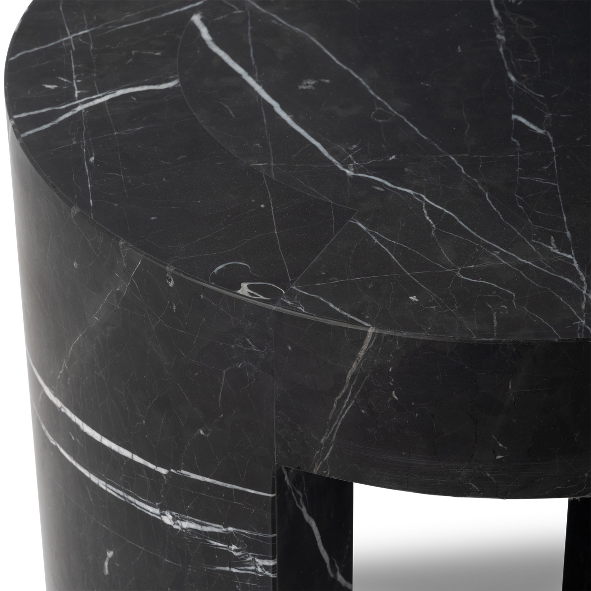Close-up showing the top and apron of the Shift Side Table in Black Nero Marquina marble, with white veining on the honed surface and the leg meeting the underside of the top.