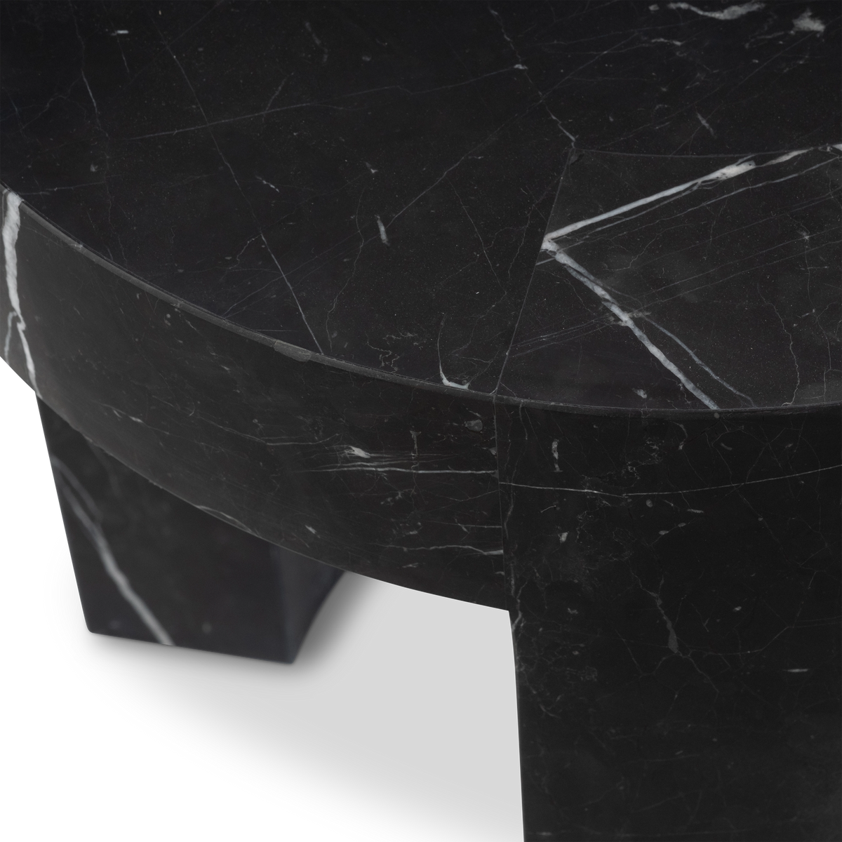Close-up of the edge of the Shift Side Table in Black Nero Marquina marble, highlighting the clean rim, fine hairline veins, and the arched leg below.