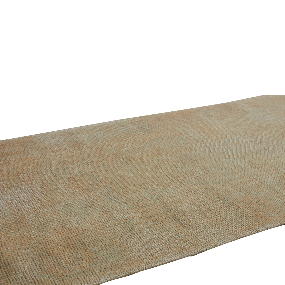 A close-up of a woven rug or textile in a warm tan/beige color, shown diagonally against a plain white background.