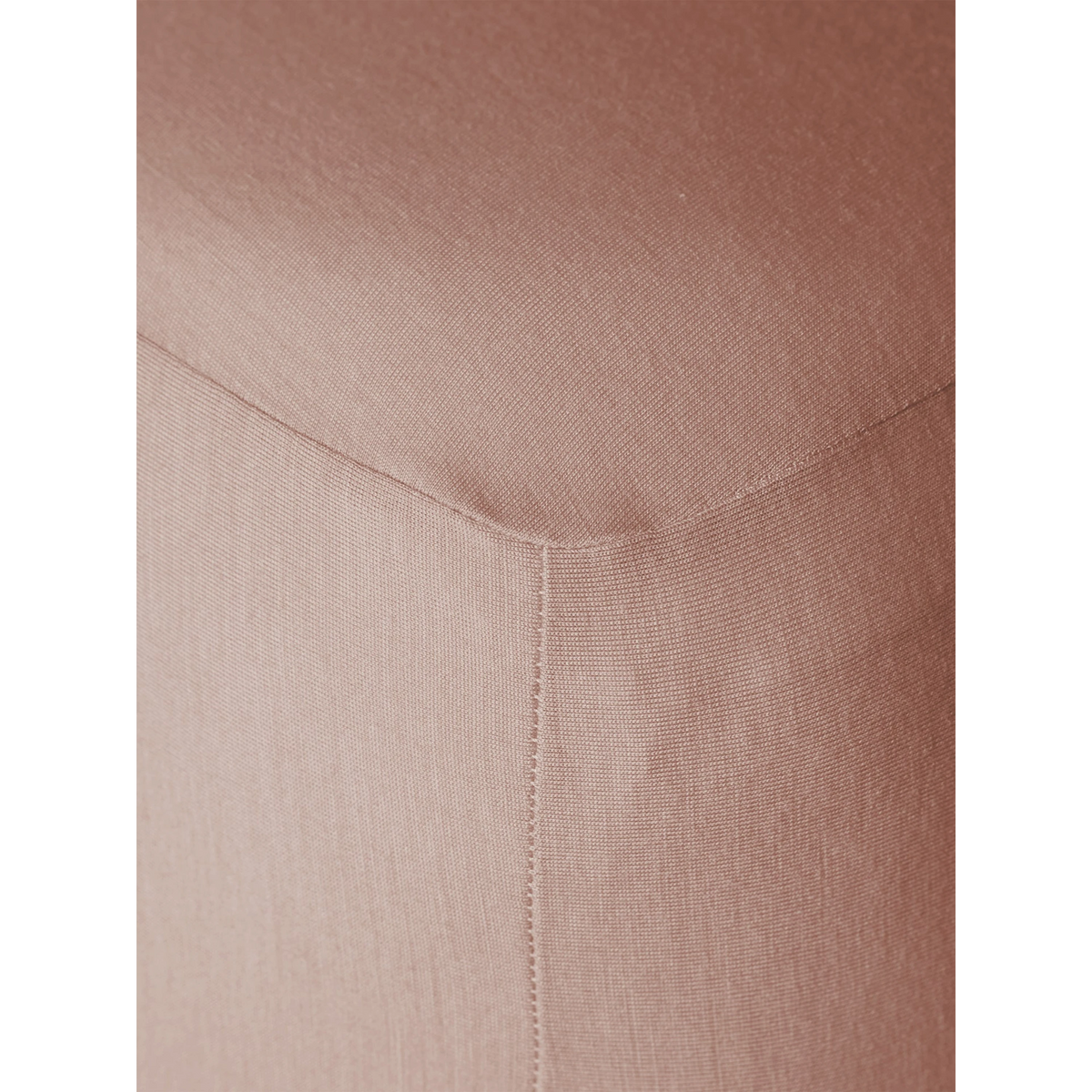 Close-up of Merino Fit Sheet King in Rose showing the smooth jersey texture, fitted corner and tailored seam detail.