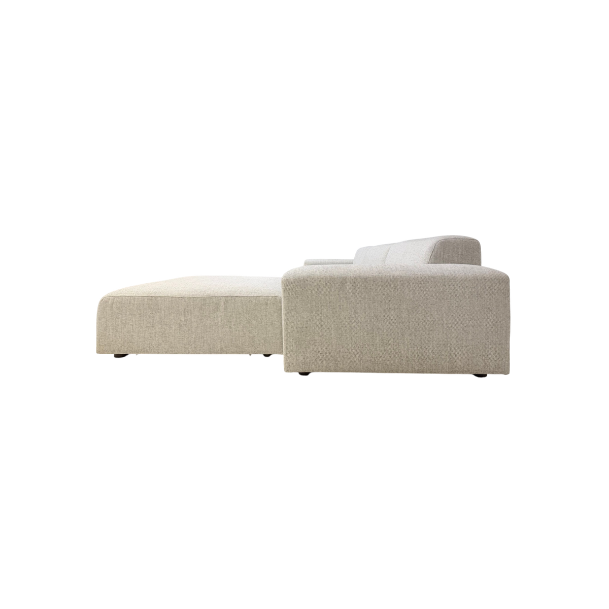 Vetro Bullnose Sectional in light woven grey upholstery, side-rear view highlighting the streamlined profile and chaise extension.