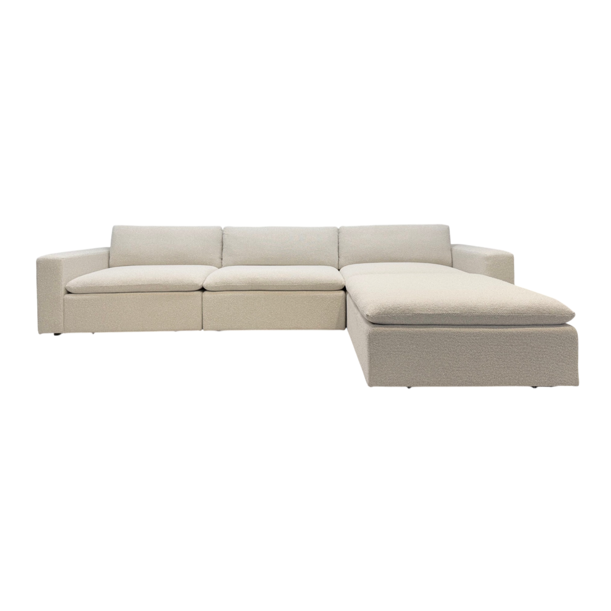 Tempo Modular Sectional front view in ivory textured upholstery, featuring a low-profile modular frame, oversized loose cushions, and an extended chaise.